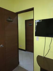 een kamer met een deur en een televisie in een kamer bij Luis Bay Travellers Lodge in Coron