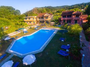 an overhead view of a swimming pool with chairs and umbrellas at The Seahorse in Sidari