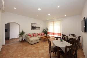 a living room with a couch and tables and chairs at Guest House Villabianca in La Maddalena
