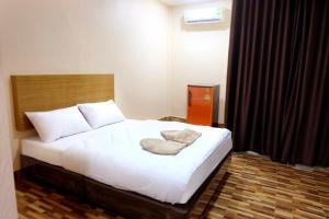 a bedroom with a bed with white sheets and pillows at Banpong Center Place in Ban Khung Phayom