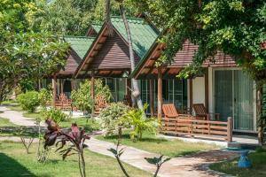 a house with a porch and chairs in the yard at Marine Chaweng Beach Resort in Chaweng