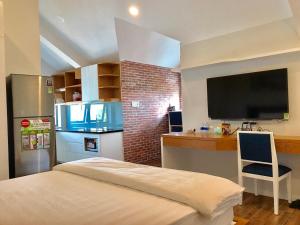 a room with a kitchen with a bed and a television at Ocean Pearl Villa in Vung Tau