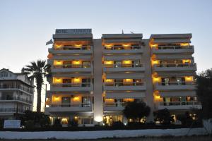 - un grand bâtiment blanc avec des lumières jaunes dans l'établissement Chaliotis Apartments, à Lefkandi Chalkidas