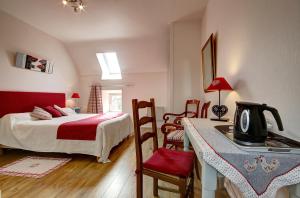 a bedroom with a bed and a table with a coffee maker at A la Ferme de Kervihern in Locoal-Mendon