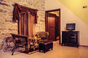 sala de estar con sillas, mesa y TV en Mouzaliko Guesthouse Mansion, en Kambos
