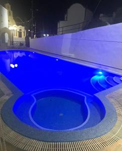 a large blue swimming pool at night at Hotel Hellas in Fira