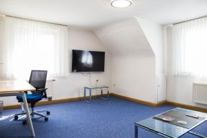 フリードリヒスハーフェンにあるPE Loft Centralのデスク、壁掛けテレビ付きのオフィス