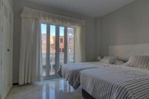 Posteľ alebo postele v izbe v ubytovaní Apartamentos Aloha2 El Puerto de Santa Maria