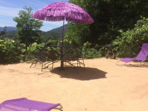 Grosseto-PrugnaにあるA Pivarellaの砂の紫の傘と椅子