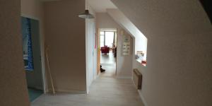 un pasillo con un pasillo que conduce a una habitación en appartement au gagne petit 25 kilomètres du parc le pal, en Bourbon-Lancy 1 foto más