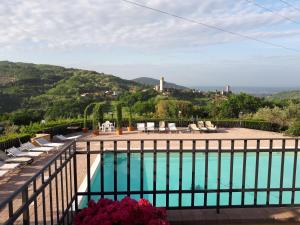 a view of a swimming pool from a balcony with chairs at Agriturismo Villa Bracali in Serravalle Pistoiese