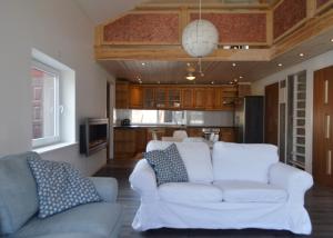 a living room with a white couch and a kitchen at Spacious home in a tranquil village setting in Ockelbo +10 photos