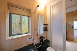 baño con lavabo, espejo y ventana en Kyo Machiya Ryokan Yuan, en Kioto