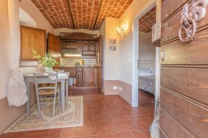 a kitchen with a table and a room with a bed at L'orto di Hans in Soriano nel Cimino