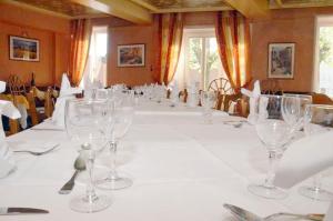 een lange tafel met lege wijnglazen erop bij Hotel du Commerce in Pont-de-Vaux