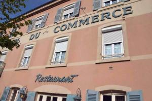 a pink building with a sign on the side of it at Hotel du Commerce in Pont-de-Vaux