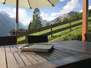 a wooden table with an umbrella on a table with a view at Chalet Maiskogel Kaprun in Kaprun
