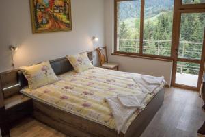 a bed in a bedroom with a large window at Guest House Milka in Yagodina