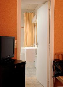 a bathroom with a television and a bathroom with a sink at Auriane Porte De Versailles in Paris