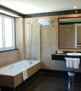 a bathroom with a sink, toilet and bathtub at Arcea Gran Hotel Pelayo in Covadonga
