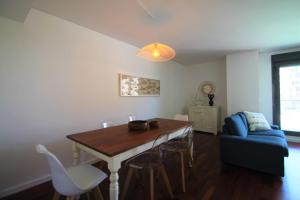 a living room with a dining room table and a couch at CasaTuris Playa, piscina y parking en Residencial San Juan SJ102 in Alicante