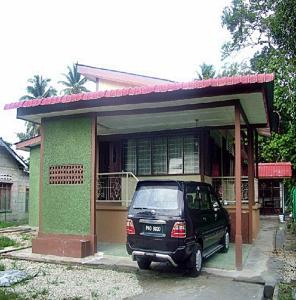 un coche aparcado frente a una casa en Villasayang Homestay en Mersing