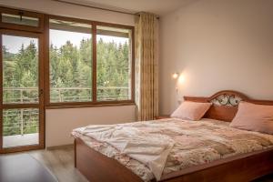 a bedroom with a bed and a large window at Guest House Milka in Yagodina