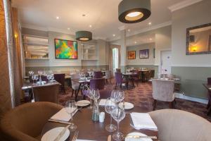 a dining room with tables and chairs in a restaurant at London Chigwell Prince Regent Hotel, BW Signature Collection in London