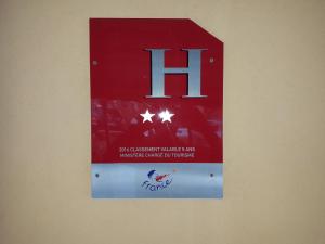 un signe sur un mur avec le h sur le mur dans l'établissement Hotel Le Terminus, au Lavandou
