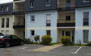a black car parked in front of a building at L'Océanide - Appartement avec balcon-terrasse et parking privé in Pont-lʼAbbé
