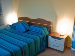 una camera da letto con un letto con lenzuola blu e due lampade di B&B Borgo Tre Case a Cavriana