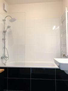 a white bathroom with a tub and a sink at Apartment DOWNTOWN in Brno