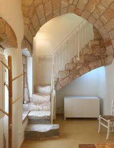 a staircase in a house with a stone wall at Basiliscus in Sternatia