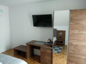 a room with a desk and a television on a wall at Villa Lucija in Poljanak