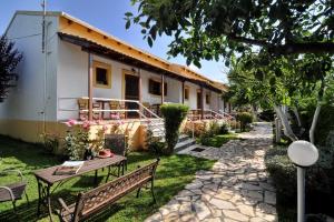 a building with a table and benches in a yard at Skafonas Apartments in Pelekas