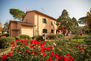 una casa en un jardín con flores rojas en Residence Mugello Resort, en Scarperia