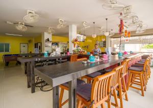 un restaurant avec un long bar et des chaises en bois dans l'établissement Tropical Sands, à Nai Harn Beach