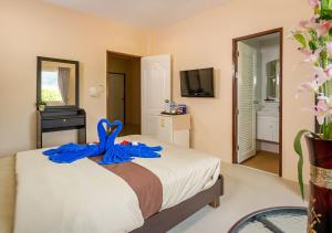Un dormitorio con una cama con una cinta azul. en Tropical Sands, en Nai Harn Beach