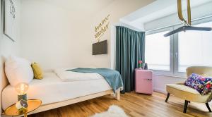 a bedroom with a bed and a chair and a window at Victoria Hotel in Düsseldorf