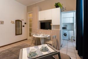 un soggiorno con tavolo e cucina di Love & Smile Apartment by Rent All Como a Como