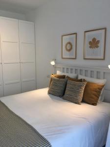 een slaapkamer met een groot wit bed met kussens bij Riflessi di Lago in Dorio