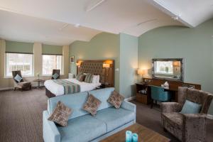 a hotel room with a bed and a blue couch at New Lanark Mill Hotel in Lanark