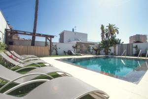 una piscina con tumbonas junto a un edificio en Pixel en Torremolinos