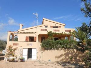 una casa blanca con una palmera delante de ella en Cala Maria, en L'Ampolla