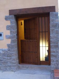 una puerta de madera en un edificio de piedra con ventana en Alojamientos rurales Angelita, en Olocau del Rey
