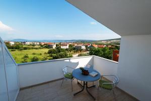 een balkon met een tafel en stoelen en uitzicht bij Apartmani LIVAJA in Plano