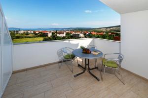 een tafel en stoelen op een balkon met uitzicht bij Apartmani LIVAJA in Plano
