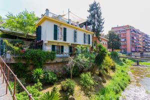 a yellow and white house on the side of a river at B&B Casa Florinda in Rapallo