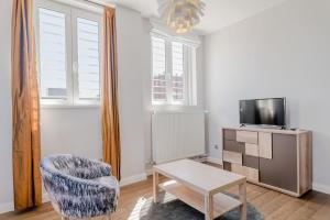 - un salon avec une chaise et une télévision dans l'établissement Top of the city Apartment with AC, à Budapest