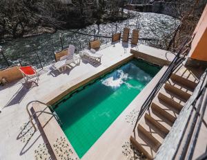 a swimming pool on a deck with chairs and stairs at Hotel Holiday Maria in Băile Herculane